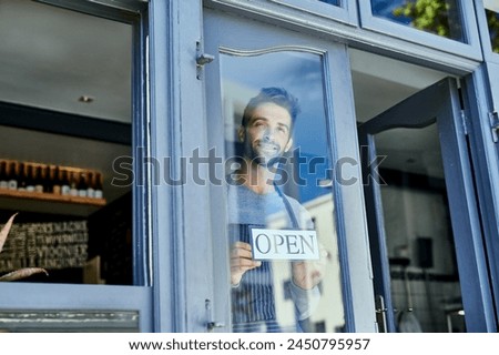 Manager, window and open sign in cafe for small business with welcome, service industry and startup. Male entrepreneur, opening time and signage by door for advertising, barista job and coffee shop