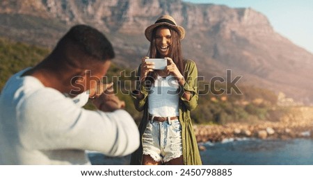 Couple, photography and beach with phone for road trip, memory or outdoor moment together in nature. Woman or photographer taking picture of man, boyfriend or partner with mobile smartphone by ocean