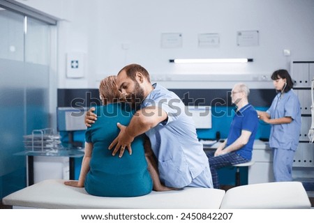 Nurse in blue scrubs treating old woman with back and spine pain for physical recovery. Chiropractic doctor giving assistance to retired patient with spinal cord injury and orthopedic care. Royalty-Free Stock Photo #2450842207
