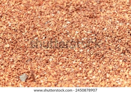Small orange crushed stone. As a background. Royalty-Free Stock Photo #2450878907