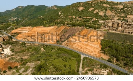 Aerial view of the former Monteponi mine, near Iglesias in Sardinia, Italy. The red color is due to the zinc and lead present in the soil. The mining plant is now closed. Mining concept. Royalty-Free Stock Photo #2450906573