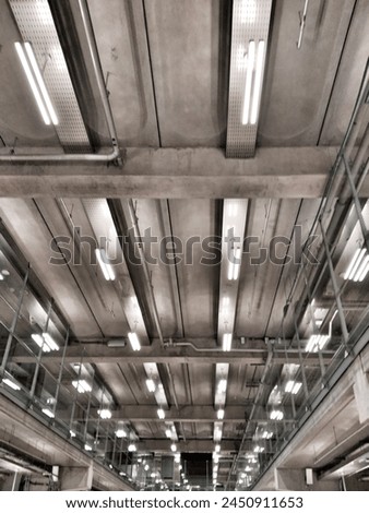 An image showcasing a modern interior industrial design with fluorescent lighting and visible ductwork reflecting a sleek urban style