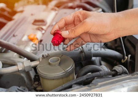 Picture of car service worker' s hand repairing vehicle in garage. Car service maintenance work. Selective focus.