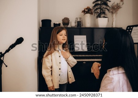 Young mom and little preschooler daughter at home learn sign language together, female nanny or teacher talk nonverbal with small disabled kid, practice sounds and signs making gestures Royalty-Free Stock Photo #2450928371