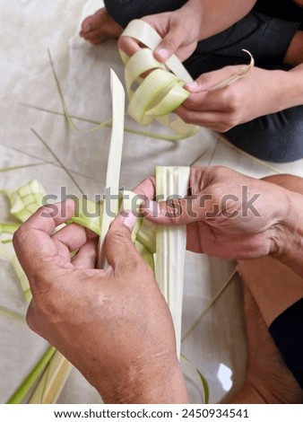The activity of manually weaving young coconut leaves to make ketupat wrappers. Activities that are often carried out on Eid al-Fitr. Ungaran, Indonesia, April 10, 2024.