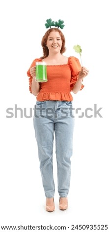 Young redhead woman with paper clover and beer on white background. St. Patrick's Day celebration