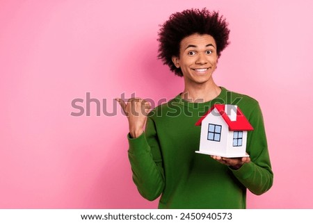 Photo of happy positive guy hold house indicate promo on empty space isolated pastel color background