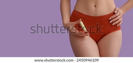 Young woman in menstrual panties and with tampon on lilac background with space for text