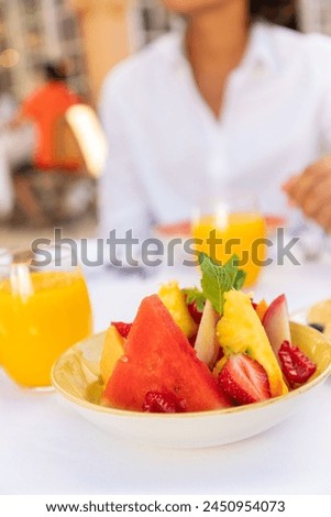 Sliced fruits assortiment in white plate on table with a white nape and a man with a white shirt Royalty-Free Stock Photo #2450954073