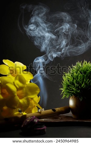Incense burning in an incense burner clay bowl on the table with dark background, Religion concept, Puja dhunuchi with smoke, Equipment of Puja festival text space. Vishu kani Festival
