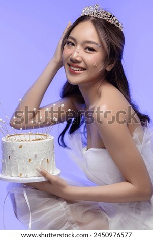 Happy beautiful Asian girl in princess dress showing birthday cake. Birthday princess photography theme is popular in social network. Royalty-Free Stock Photo #2450976577