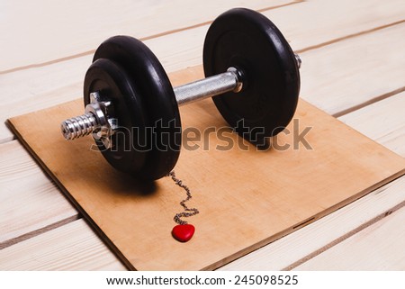 dumbbell with a red heart on a chain
