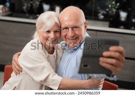 Smiling senior couple taking selfie at home. Portrait of senior couple