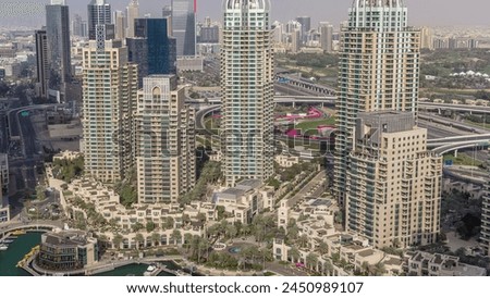 Aerial top view of Dubai Marina evening timelapse. Promenade and canal with floating yachts and boats before sunset in Dubai, UAE. Modern towers and traffic on the road
