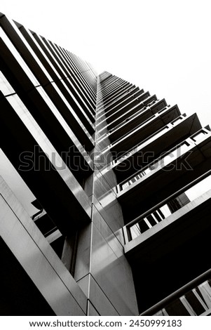 Black and white photograph of a tall city skyscraper.
