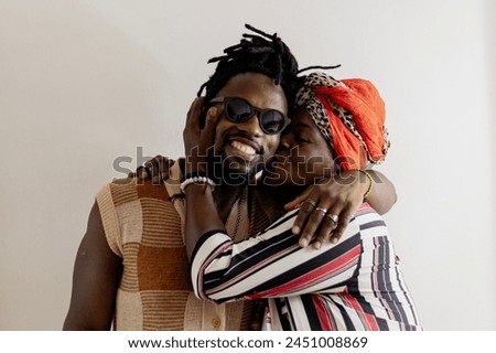 Portrait of a mother affectionately hugging and kissing her son. African mother. Black mother. Mother wearing colorful African clothes. Royalty-Free Stock Photo #2451008869