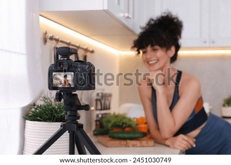 Food blogger explaining something while recording video in kitchen, focus on camera Royalty-Free Stock Photo #2451030749