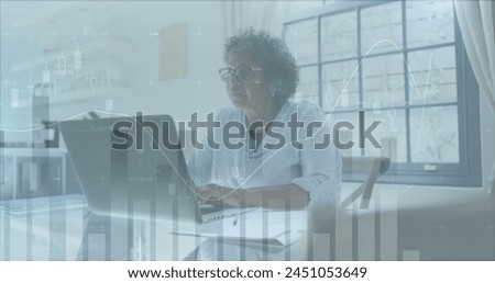Image of financial data processing over senior woman using laptop paying bills online at home. global finances and business concept digitally generated image.