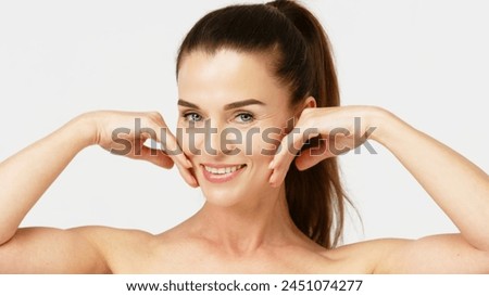 Gorgeous middle aged woman touching her perfect skin. Beautiful portrait of a 40-50 year old woman advertising anti-aging facial products, salon care, skin tightening, isolated on white background. Royalty-Free Stock Photo #2451074277