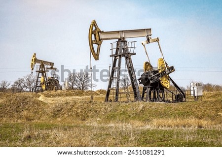 Crude oil pump jack at oilfield. Fossil crude output and fuels oil production. Oil drill rig and drilling derrick. Industrial theme