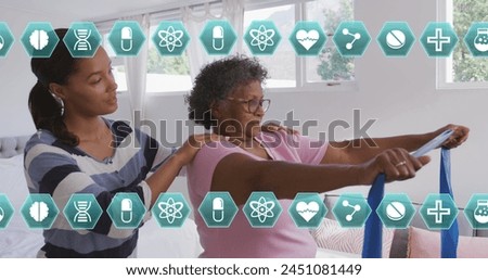 Image of medical icons over senior woman exercising using rubber band with female therapist. global coronavirus pandemic, medicine and healthcare concept digitally generated image.