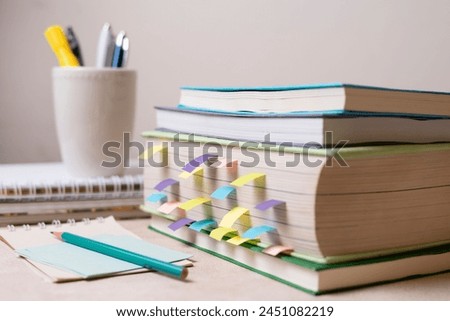Photo close up of stack of books on top of a table. Coloured books in the classroom 