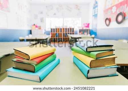 Photo close up of stack of books on top of a table. Coloured books in the classroom 
