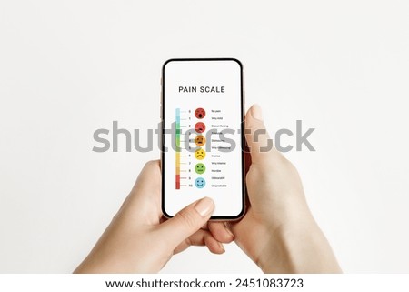 female hands holding a phone with a pain measurement scale isolated over white background. Test online