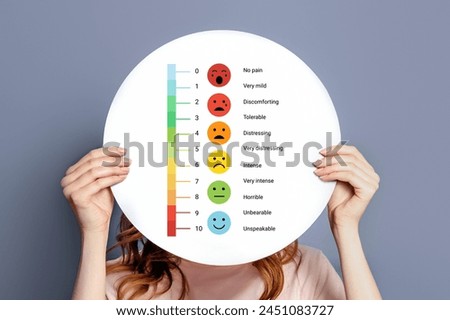 girl holding a poster with a pain measurement scale.. mental health concept