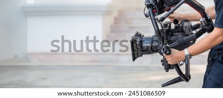 Movie shooting or video production and film crew team with camera equipment. Video camera operator working with equipment. Director of photography with a camera in his hands on the set