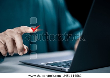 Checklist concept. Businessman using laptop tick correct mark in checkbox on virtual screen.
