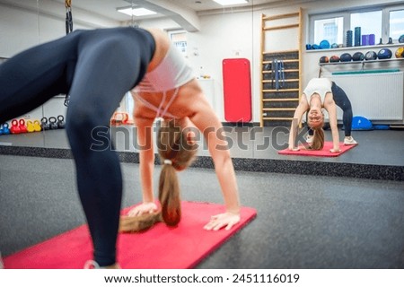 Young woman works out in the gym performing an exercise for strong body and health. High quality photo
