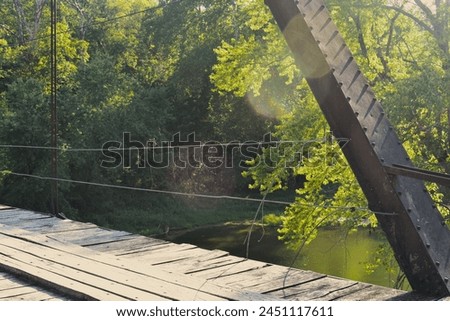 William's Bend Bridge, aka Rough Holler Bridge, is a historic steel truss bridge with wooden flooring, spanning the Pomme de Terre river near Hermitage, MO, United States, US. It was built in 1890. Royalty-Free Stock Photo #2451117611