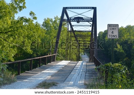 William's Bend Bridge, aka Rough Holler Bridge, is a historic steel truss bridge with wooden flooring, spanning the Pomme de Terre river near Hermitage, MO, United States, US. It was built in 1890. Royalty-Free Stock Photo #2451119415