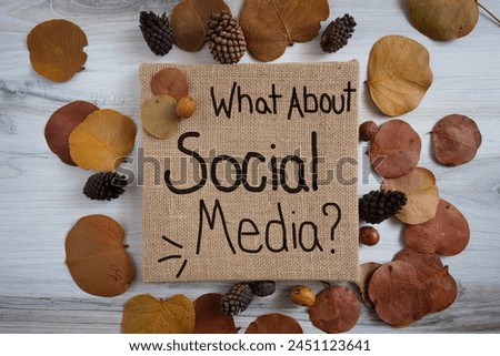 Fall autumn flat lay square brown sign, what about social media? Hand written on it. Pine cones, fall leafs and acorns scattered.
