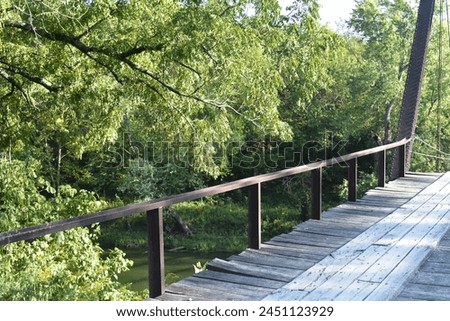 William's Bend Bridge, aka Rough Holler Bridge, is a historic steel truss bridge with wooden flooring, spanning the Pomme de Terre river near Hermitage, MO, United States, US. It was built in 1890. Royalty-Free Stock Photo #2451123929