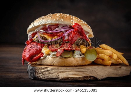 Burger with puffy beef patty, grilled sweet peppers. Juicy delicious hamburger on darkmood picture for restaurant decoration, poster. 