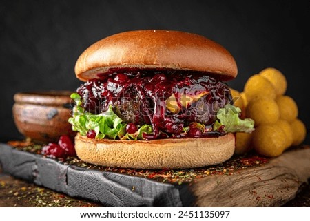 Gourmet Burger with beef steak, cranberry sauce. Juicy delicious hamburger on darkmood picture for restaurant decoration, poster. 