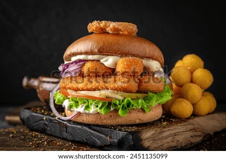 Gourmet fish burger with battered rowan sticks, cheese and vegetables. Juicy delicious hamburger on darkmood picture for restaurant decoration, poster. 