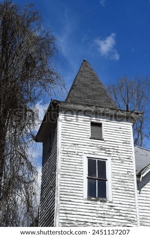 Esther Church is in disrepair.  Paint is cracked and peeling, vines are overtaking structure, and wood is rotting. Royalty-Free Stock Photo #2451137207