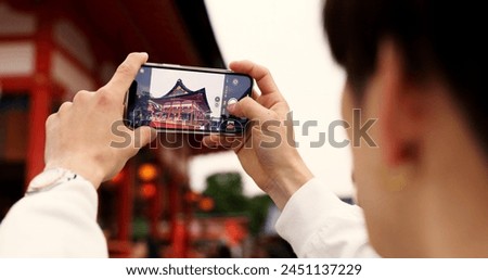 Phone, hands and tourist with picture in Japan on vacation, holiday trip or travel. Smartphone, person and closeup photography of Fushimi inari-taisha temple in Kyoto on mobile technology outdoor