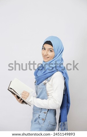 Time Management At Work. Smiling Islamic Female Employee Writing Notes, Managing Her Business 
