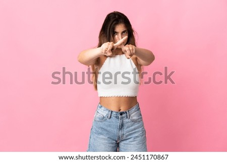 Young caucasian woman isolated on pink background making stop gesture with her hand to stop an act