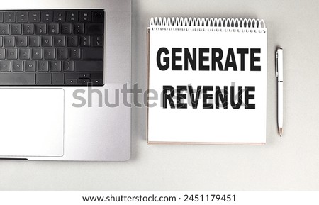 GENERATE REVENUE text on a notebook with laptop and pen . 
