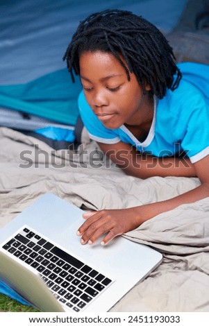 Child, relax and play with laptop in tent with cartoon, movie or online games on holiday or vacation. Kid, smile and watch video on streaming, website or search on internet for computer elearning