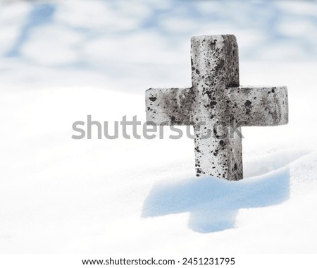 A marble cross in the snow.