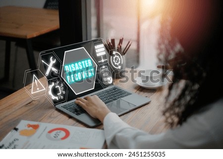 Disaster recovery concept, Buinesswoman using laptop computer on desk with disaster recovery icon on virtual screen. Royalty-Free Stock Photo #2451255035
