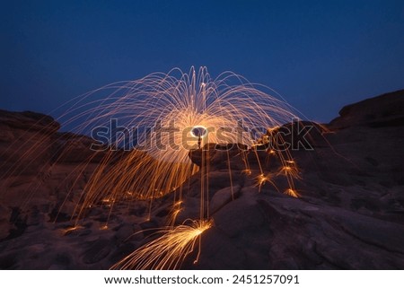 Burning steel wool fireworks, the grand canyon of Thailand (3000 bok) at Sam Pan Bok, Mekong River, Ubon Ratchathani, Thailand. Royalty-Free Stock Photo #2451257091
