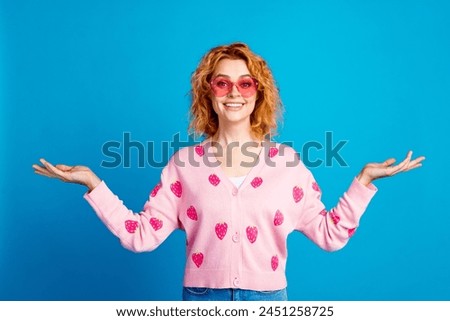 Photo portrait of attractive young woman touch sunglass compare empty space dressed stylish pink clothes isolated on blue color background