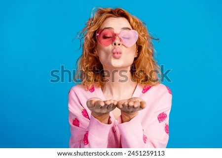 Photo portrait of attractive young woman sunglass send air kiss closed eyes dressed stylish pink clothes isolated on blue color background